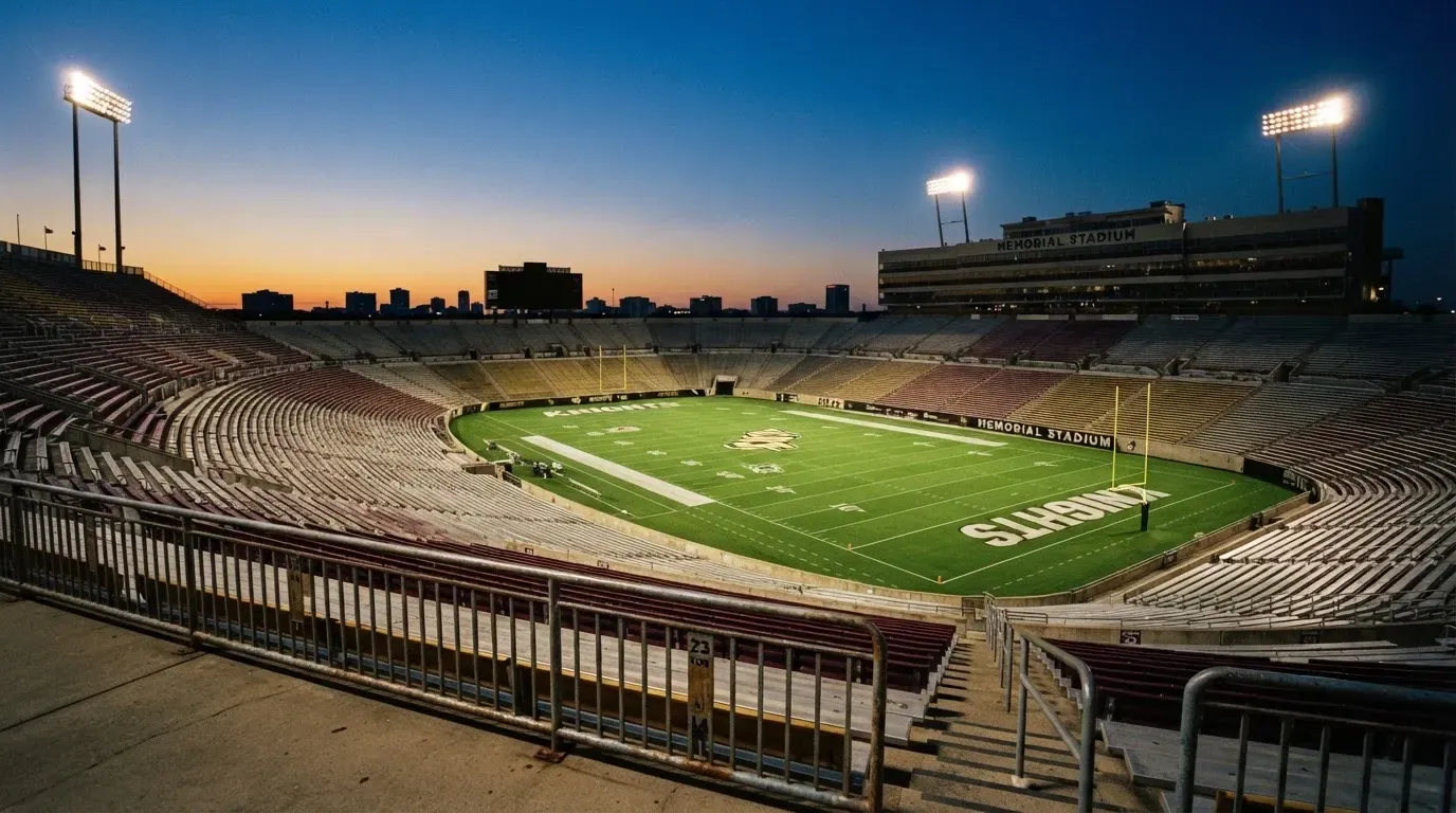 An empty football stadium with floodlight masts at dusk